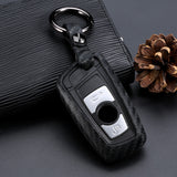 Black car key fob cover with keychain on a dark textured surface